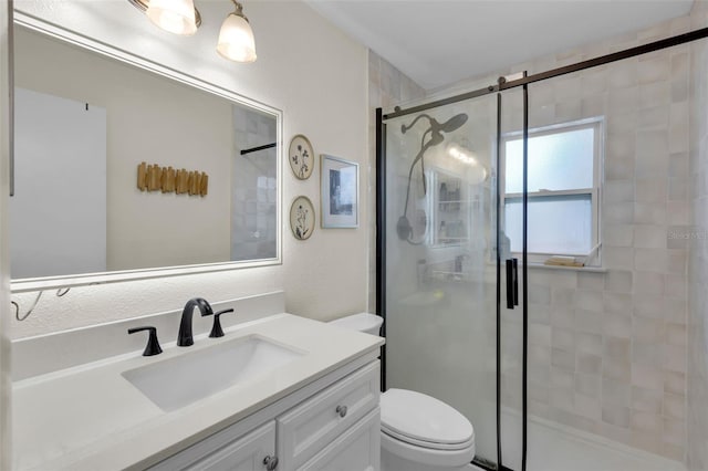 bathroom featuring toilet, a stall shower, and vanity