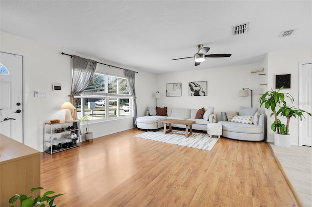 living area with a ceiling fan, light wood-type flooring, and visible vents