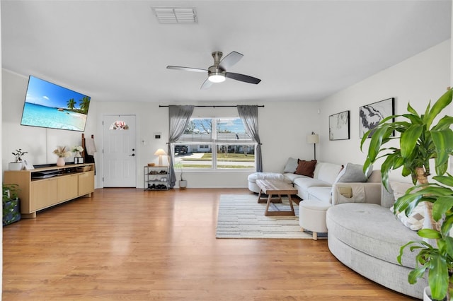 living area with light wood finished floors, visible vents, and a ceiling fan