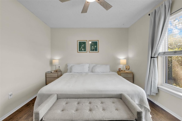 bedroom featuring dark wood-style floors, ceiling fan, and baseboards