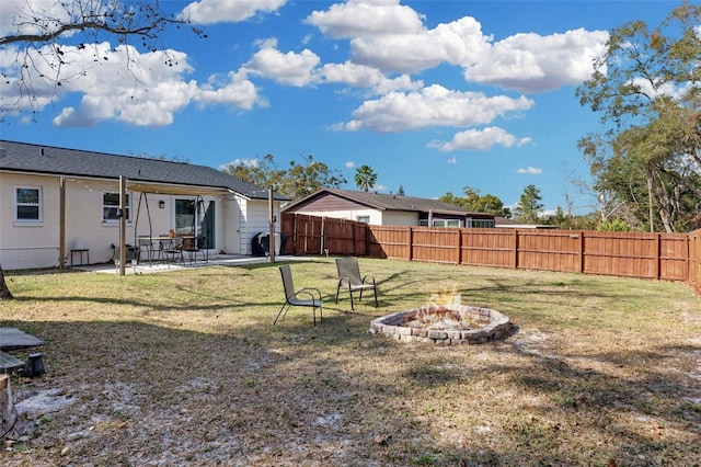 view of yard with a fire pit, a patio, and a fenced backyard