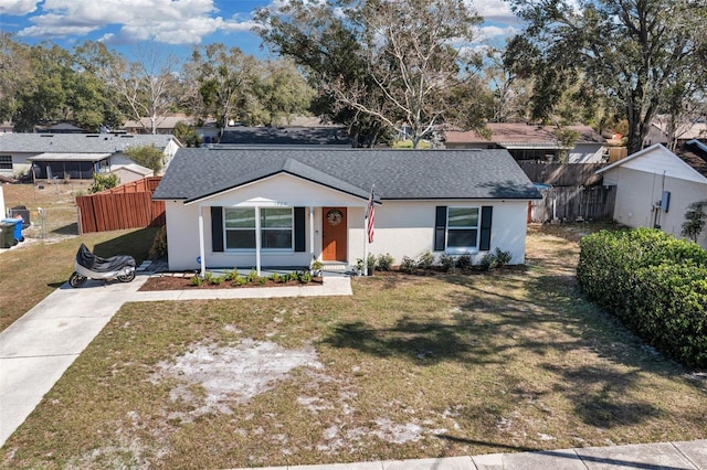 ranch-style home featuring a residential view, roof with shingles, fence, a front yard, and stucco siding