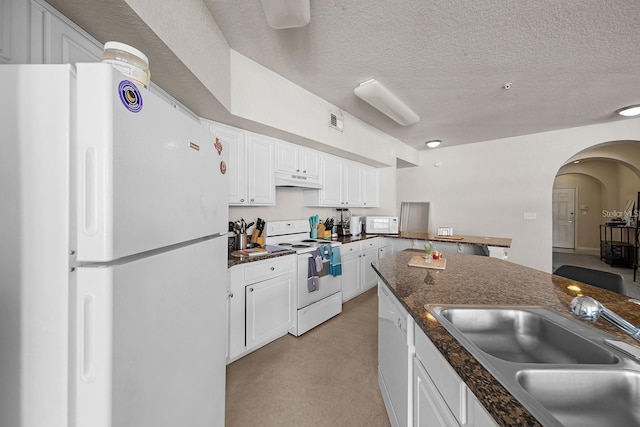 kitchen featuring white cabinetry, white appliances, sink, and dark stone countertops