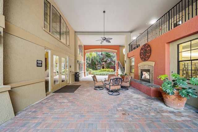 view of patio featuring a tile fireplace and ceiling fan