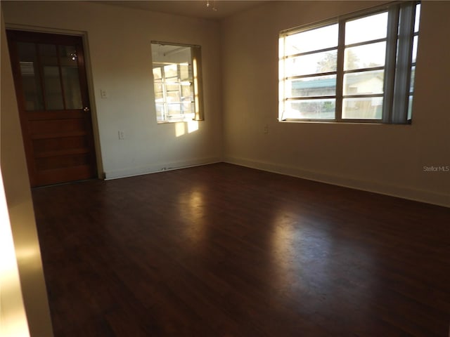 empty room with dark hardwood / wood-style flooring