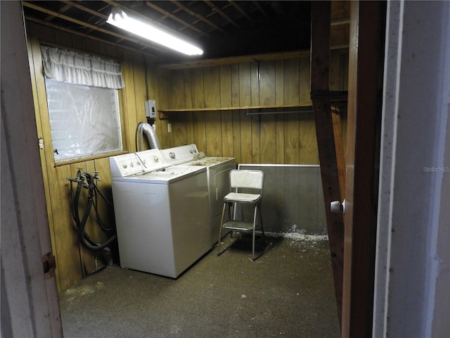 laundry room with separate washer and dryer and wooden walls