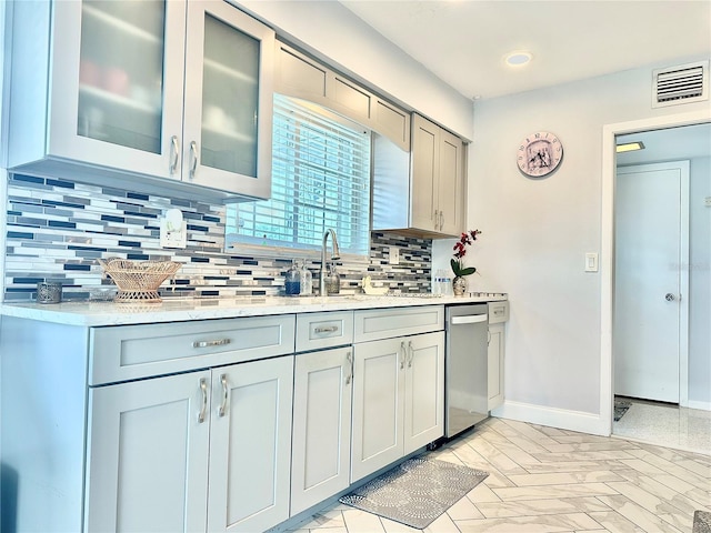 kitchen featuring gray cabinetry, sink, stainless steel dishwasher, and decorative backsplash