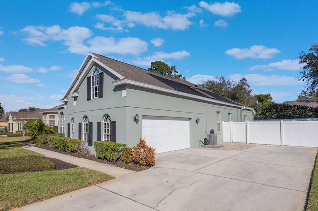 view of home's exterior with cooling unit and a garage