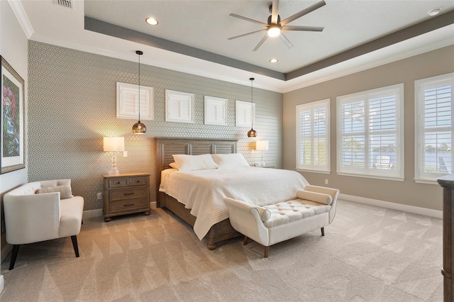 bedroom with crown molding, multiple windows, a tray ceiling, and light carpet