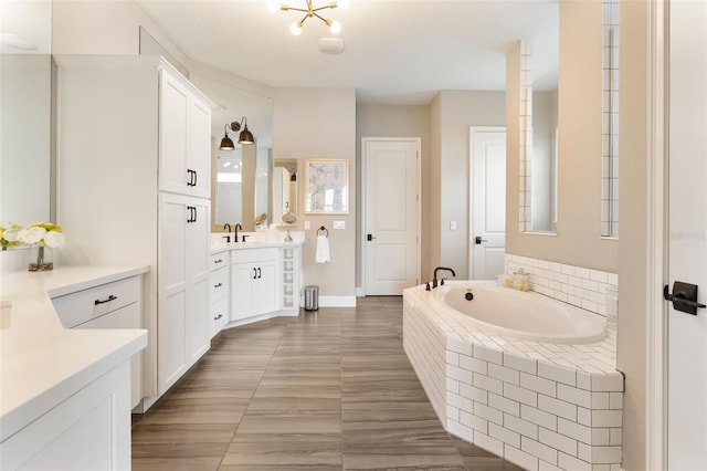 bathroom with vanity and tiled tub