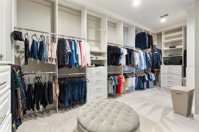 walk in closet featuring light carpet