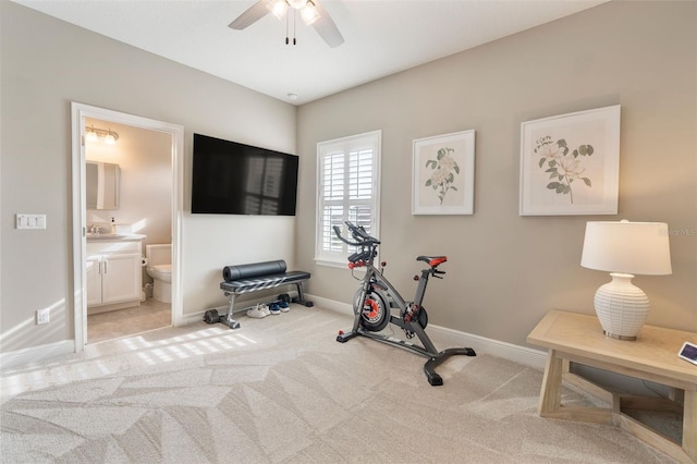 workout room featuring ceiling fan and light colored carpet