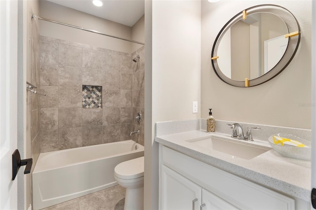 full bathroom with tile patterned flooring, tiled shower / bath, vanity, and toilet