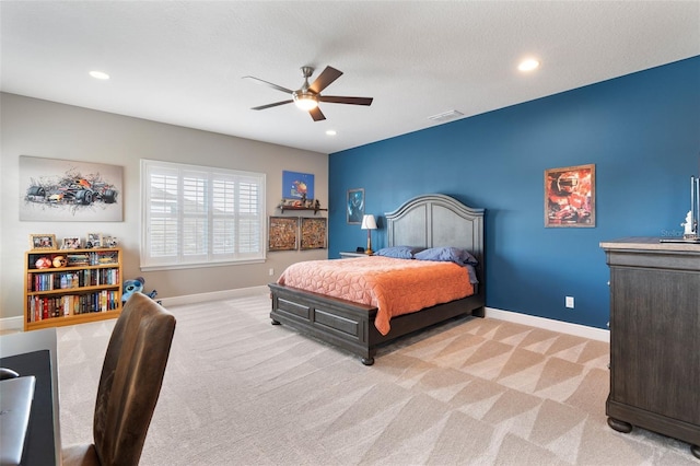 bedroom featuring light colored carpet, a textured ceiling, and ceiling fan