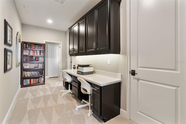 carpeted home office featuring built in desk