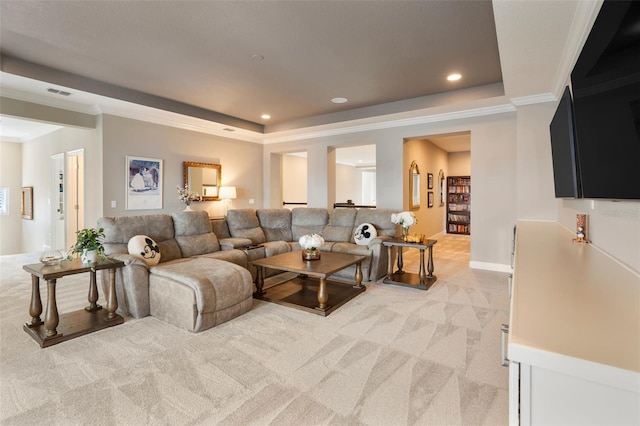 living room with crown molding, a tray ceiling, and light carpet