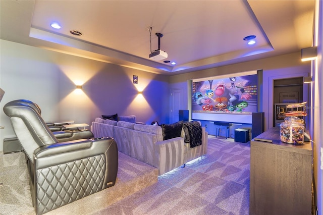 cinema room with carpet flooring and a tray ceiling