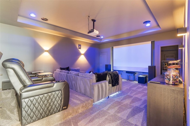 home theater featuring a raised ceiling and carpet