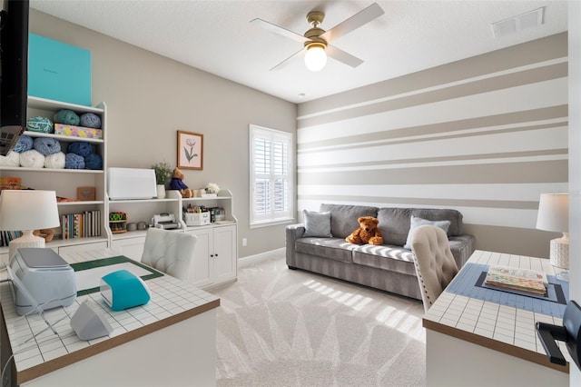 office featuring ceiling fan, light colored carpet, and a textured ceiling