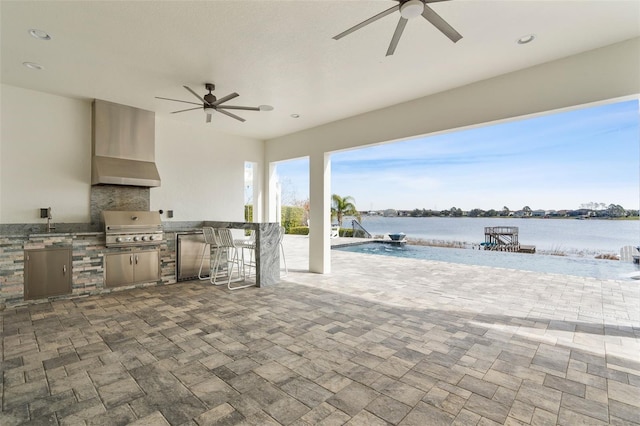 view of patio featuring a water view, area for grilling, a bar, ceiling fan, and a grill