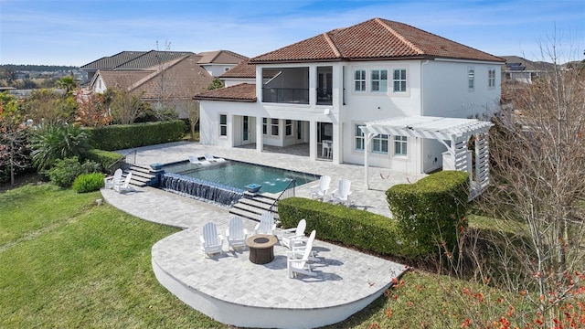 back of property with a patio, a fire pit, a lawn, and a pergola