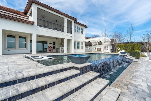 rear view of house with pool water feature, a patio area, a pergola, ceiling fan, and a fenced in pool