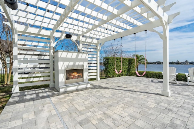 view of patio / terrace featuring an outdoor fireplace, a water view, and a pergola