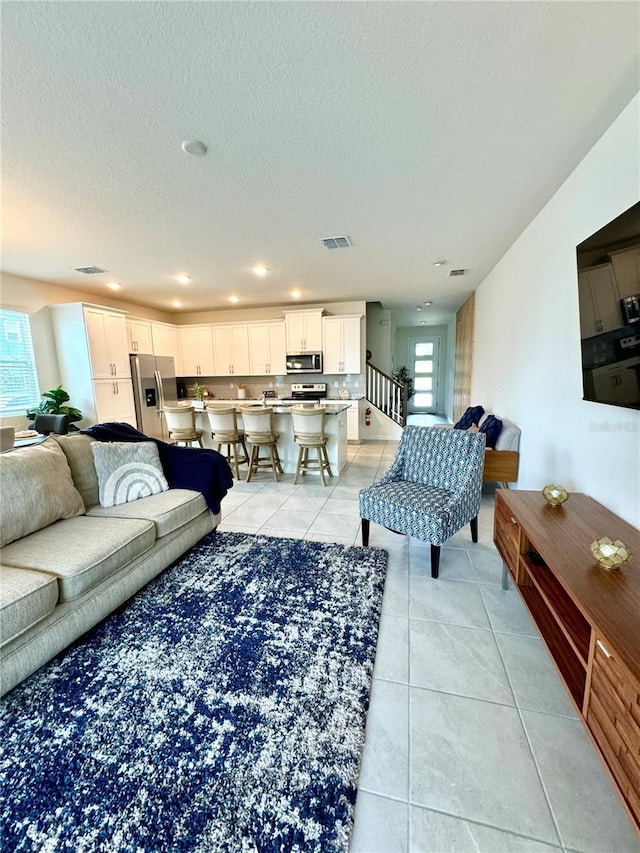 living room featuring light tile patterned floors and a textured ceiling