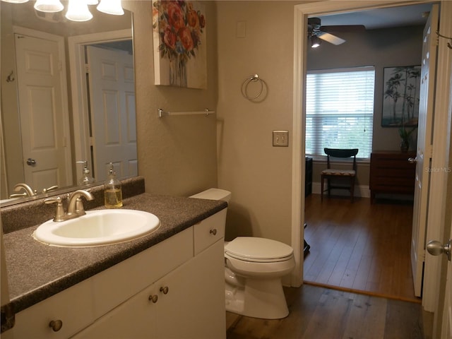 bathroom featuring hardwood / wood-style flooring, ceiling fan, vanity, and toilet