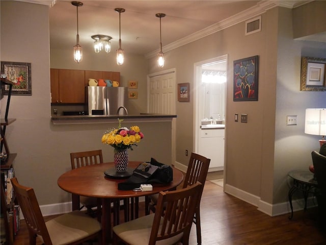 dining area featuring hardwood / wood-style flooring and ornamental molding