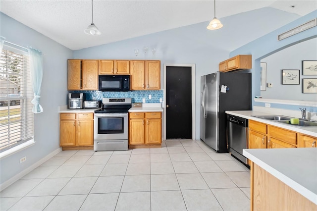 kitchen with pendant lighting, vaulted ceiling, and appliances with stainless steel finishes