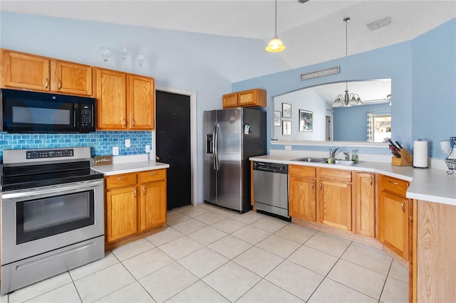 kitchen with lofted ceiling, sink, appliances with stainless steel finishes, decorative backsplash, and decorative light fixtures