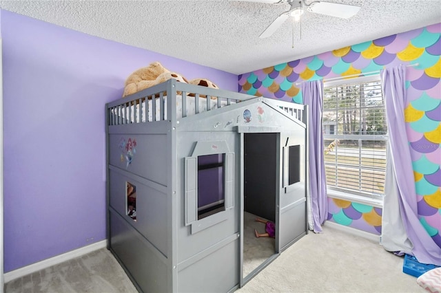 bedroom featuring ceiling fan, carpet, and a textured ceiling