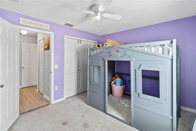 unfurnished bedroom featuring ceiling fan, carpet flooring, a closet, and a textured ceiling