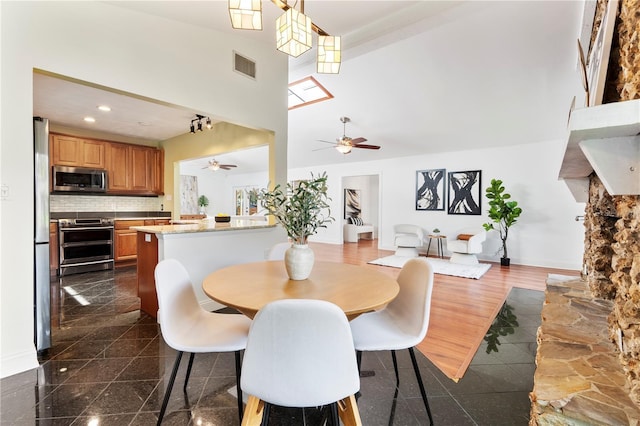 dining room featuring ceiling fan and high vaulted ceiling