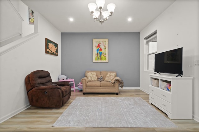 living room with light hardwood / wood-style floors and a chandelier