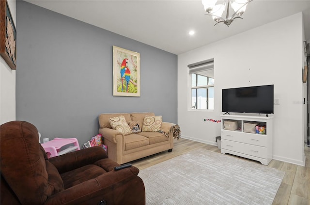 living room with an inviting chandelier and light hardwood / wood-style flooring