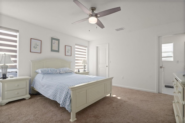 bedroom with ceiling fan, carpet flooring, and multiple windows