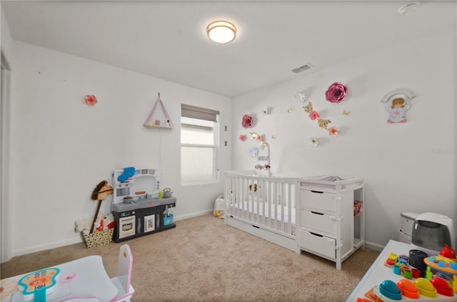 carpeted bedroom featuring a nursery area