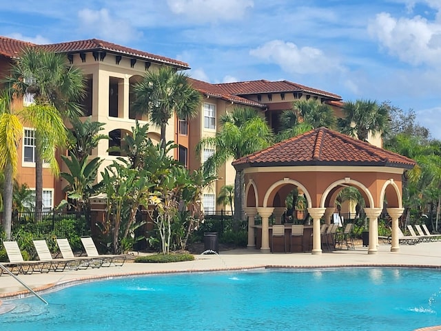 pool with a patio and fence