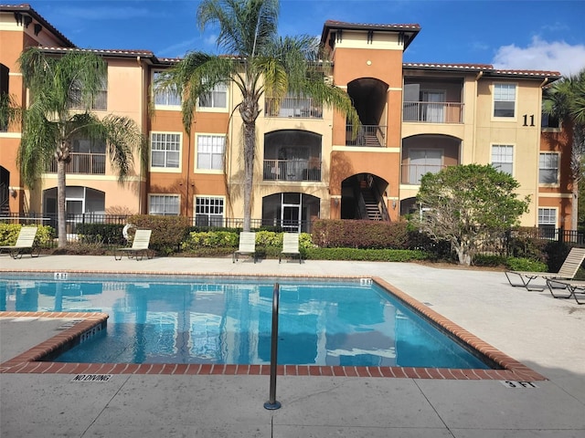 view of swimming pool featuring a patio and fence