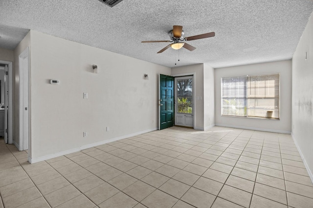 tiled empty room with a textured ceiling and ceiling fan