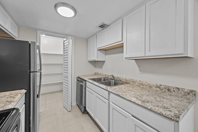 kitchen featuring white cabinetry, appliances with stainless steel finishes, sink, and light tile patterned floors