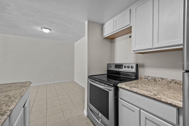 kitchen with stainless steel range with electric stovetop, light stone countertops, a textured ceiling, white cabinets, and light tile patterned flooring