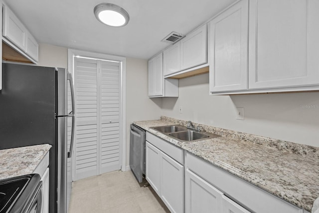 kitchen with light stone counters, appliances with stainless steel finishes, sink, and white cabinets