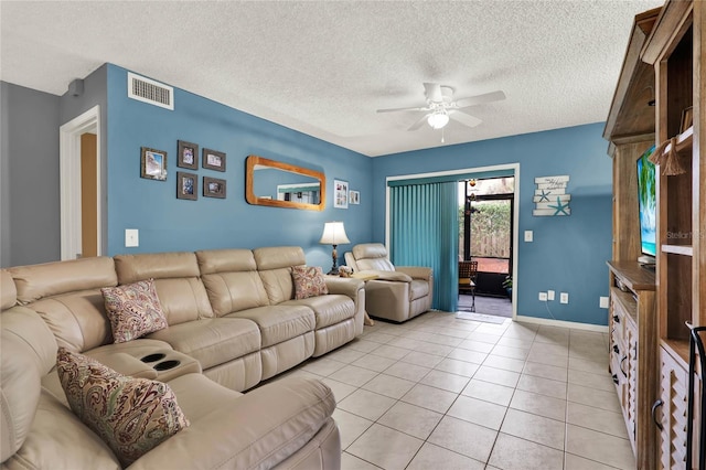 living room featuring ceiling fan, a textured ceiling, and light tile patterned floors