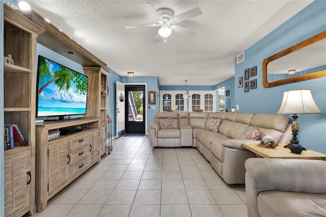 tiled living room with ceiling fan and a textured ceiling