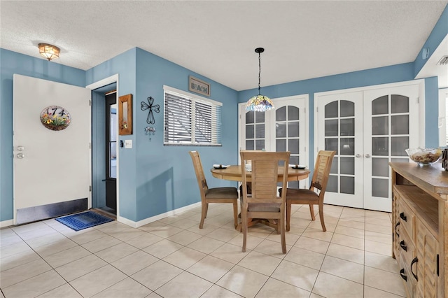 dining space featuring light tile patterned flooring, a textured ceiling, and french doors