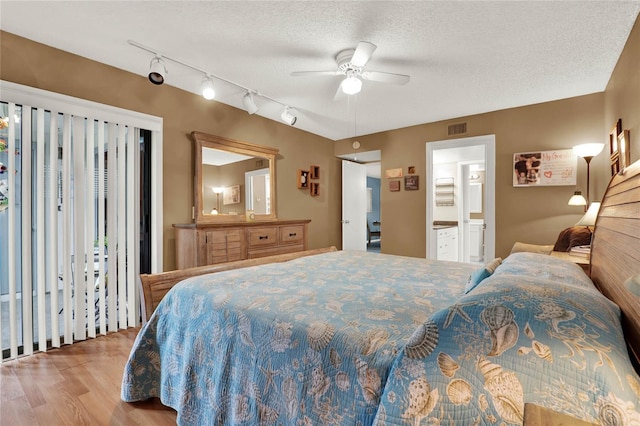 bedroom featuring ceiling fan, light hardwood / wood-style flooring, a textured ceiling, and ensuite bathroom