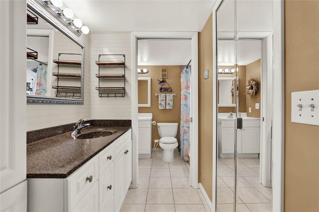 bathroom featuring vanity, tile patterned floors, and toilet